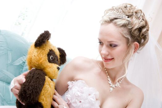 pretty blond bride with a bear toy from her childhood