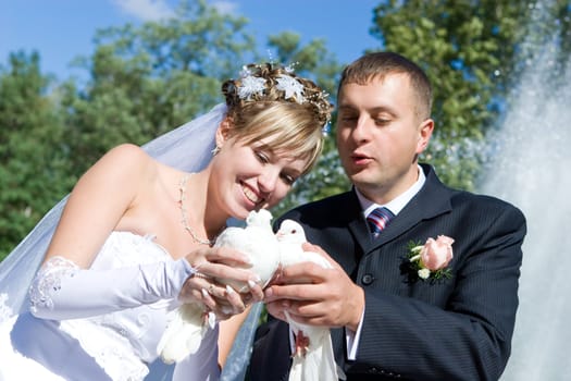 bride and groom with white pigeons in the hands