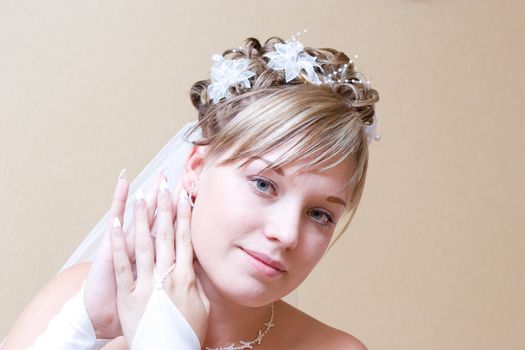 a beautiful bride carefully putting on ear-ring