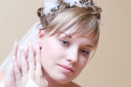 beautiful bride thingfully puts on an ear-ring