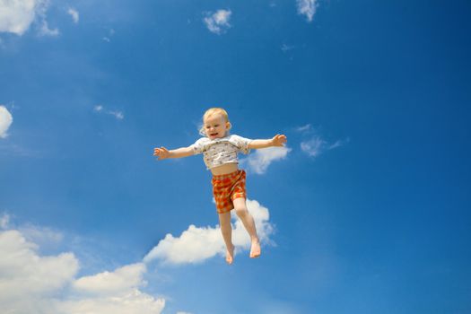 happy small girl fly in the blue sky