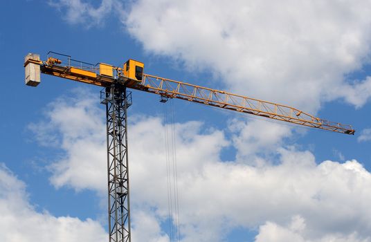 lifting crane uder blue sky with clouds