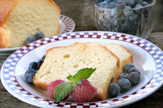 Slices of pound cake with fresh fruit served on a plate.
