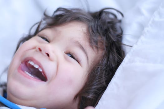 Beautiful baby boy smiling on bed