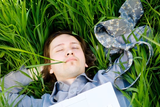 businessman rest on the grass with laptop