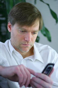 Handsome businessman using cell phone in casual attire.