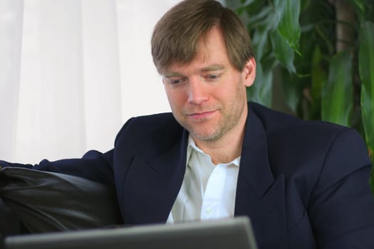 Handsome businessman working on laptop