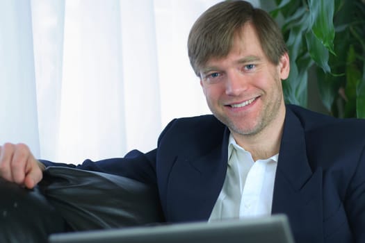 Handsome businessman working on laptop