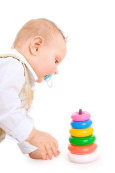 The toddler boy plays developing game. Color pyramidion.