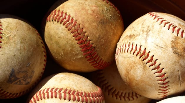 old baseballs in a bucket after a long season