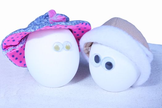 Two hardboiled eggs with eyeballs and hats, add your own expressions,