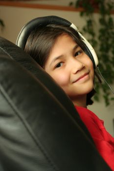 Nine year old girl listening to music with headphones. Part ASian, Scandinavian descent.