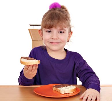 little girl eat bread with chocolate cream