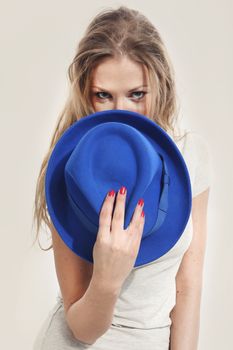 Beautiful girl holding a blue hat