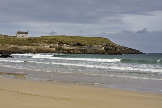 sandy coast with waves and single house in scotland