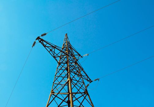 Pylon &amp; power lines against blue sky