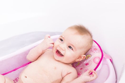 Pretty girl is having a bath in her bathtub.