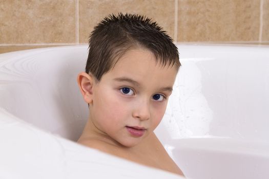 Blue eye kid is looking from bathtub.