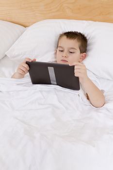 First grade kid completing his bed time reading on his tablet.