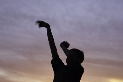 follow through of boy after shooting basketball silhouette