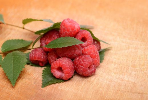 heap of ripe raspberries with leaves 