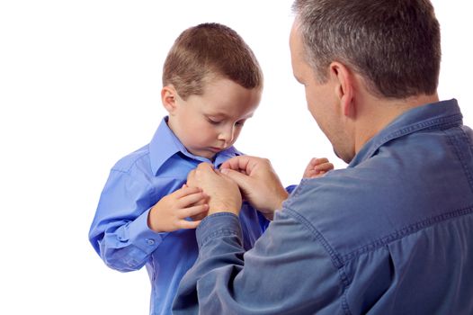 Father helping his son fastening his shirt buttons
