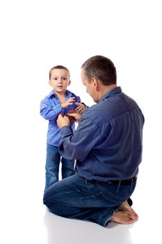 Father helping his son fastening his shirt buttons