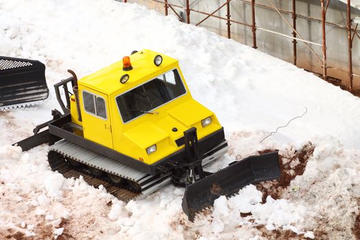 small yellow parked snowcat close up