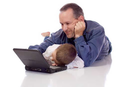 Father and son laying on their stomach with a laptop