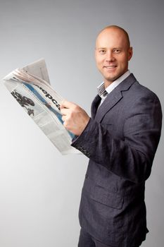 Portrait of a businessman reading a daily newspaper