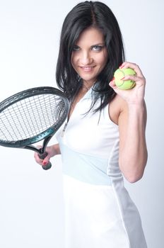Portrait of a young and beautiful girl in tennis in the form of a racket and a ball in his hands