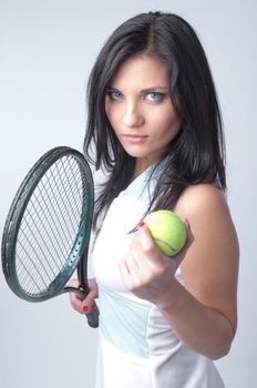 Portrait of a young and beautiful girl in tennis in the form of a racket and a ball in his hands