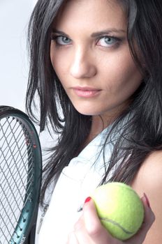Portrait of a young and beautiful girl in tennis in the form of a racket and a ball in his hands