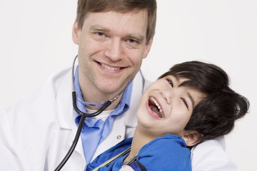 Male doctor in early forties holding five year old disabled patient during office visit