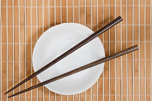 Simple arrangment of chopsticks, mat and  empty bowl