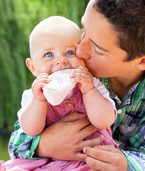 Close-up of little boy hugging and kissing adorable baby sister