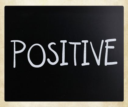 "Positive" handwritten with white chalk on a blackboard