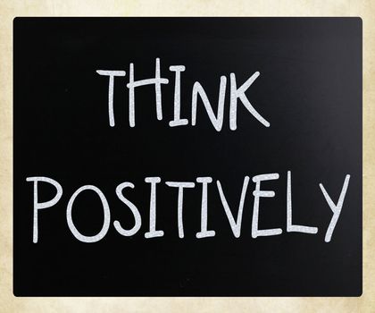 "Think Positively" handwritten with white chalk on a blackboard