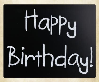 "Happy Birthday" handwritten with white chalk on a blackboard