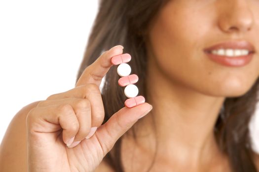 Young woman holding pills, isolated on white 