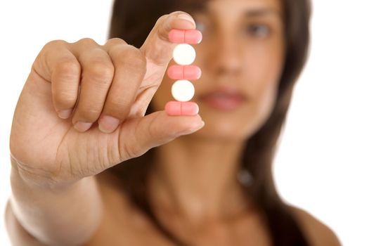 Young woman holding pills, isolated on white