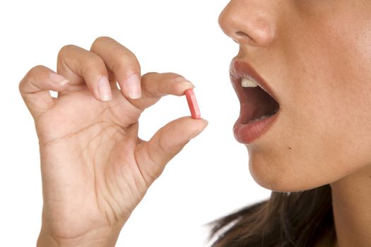 pretty young women pops a pill into her mouth 