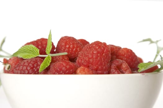 Ripe raspberry with green leaf on white background