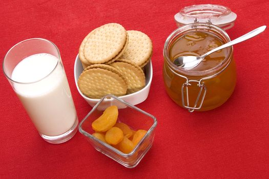 Delicious breakfast foods over red fabric background