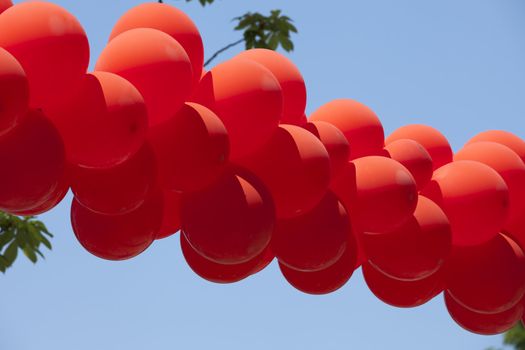 red balloons hanging over the street