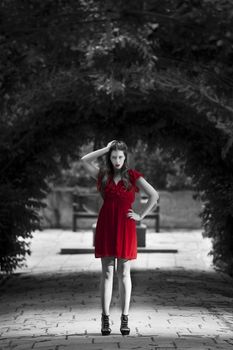 Monochrome image showing only red dress on a woman in almost intimidating stance