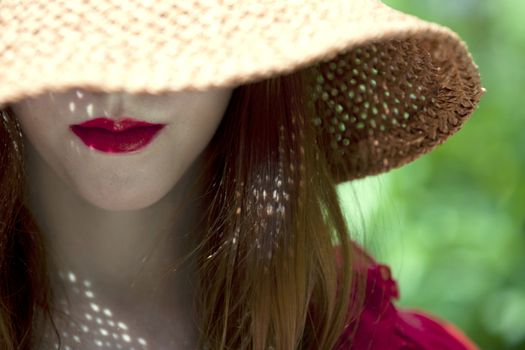 Young woman with face covered with hat only showing beautiful lips