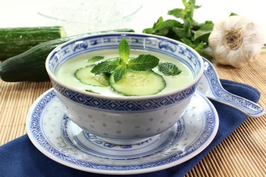 cold cucumber soup with slices of cucumber and mint