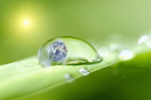 Planet earth inside a drop of dew and sunlight effect