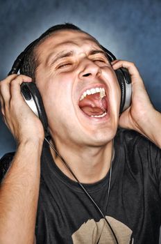 Man listen  music on headphones and scream aloud